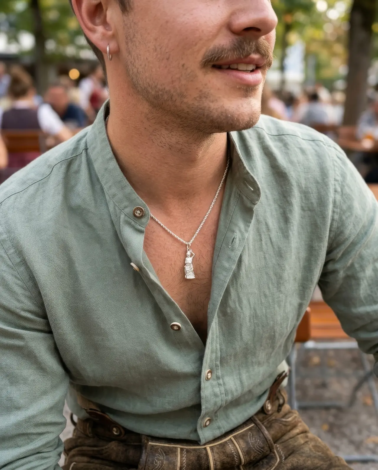 Mann in Tracht mit Bavaria Anhänger im Biergarten